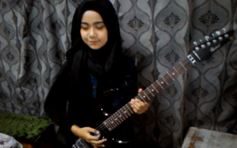 Jonge moslim meisje speelt cover Judas Priest op gitaar